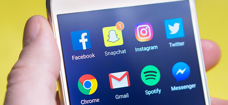 Bildschirm eines iPhones mit Apps der sozialen Netzwerke Facebook, Snapchat, Instagram, Twitter und Spotity sowie mit dem Messenger von Facebook.